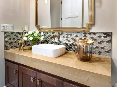 This glamorous powder bathroom treats the guests with luxury! It hosts a wall hanging walnut’s cabinets with a drop-down quartz countertop. Its unique brass faucet hung from the beautiful backsplash that centers to its vessel sink. We finish the look with beautiful brass mirror and ceiling hang pendants lights.